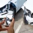Man photographing his vehicle with damages for accident insurance with smart phone.
